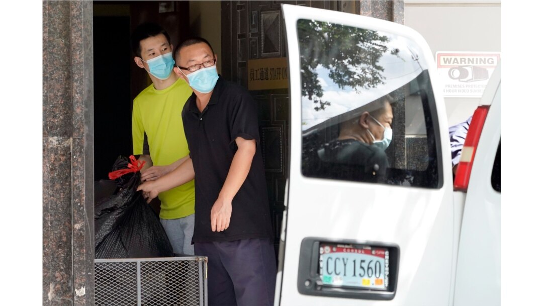People remove bags from inside the Chinese Consulate to load into a van in Houston, July 23, 2020.