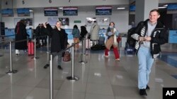 9일 러시아 블라디보스토크 공항에서 북한 행 항공기 입국을 준비 중인 단체 관광객들.