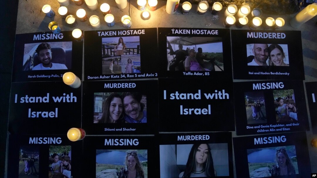 Pictures of the dead, missing and those taken hostage are displayed beside candles during the Jewish Community Vigil for Israel in London, Britain, Oct. 9, 2023.