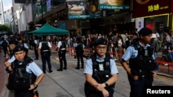 FILE - Police stand guard during an anniversary of the 1989 Tiananmen Square pro-democracy protest crackdown in Beijing, near where a candlelight vigil is usually held, in Hong Kong, June 4, 2023.