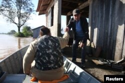 Ljudi se ukrcavaju u čamac napuštajući potopljenu kuću, tokom ciklona koji je pogodio južni grad Venansio Ajres, u državi Rio Grande do Sul, u Brazilu, 5. septembra 2023.