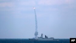 资料照片：中国海军护卫舰滨州号2022年12月27日在东中国海参加与俄罗斯军舰的联合海军演习。（美联社照片）