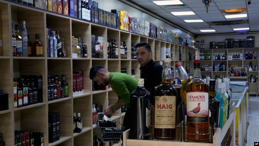 People buy alcohol in a liquor store in Baghdad, Iraq, March 9, 2023. The Iraqi government started enforcing a 2016 ban on alcoholic beverages this month, but religious minorities are pushing back against the measure.