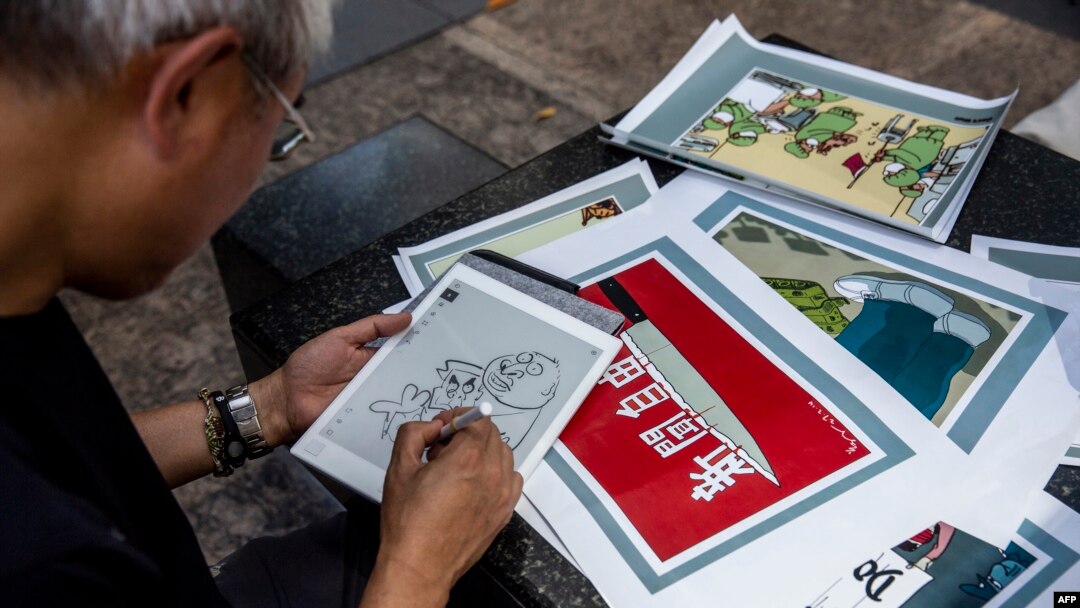 FILE - This picture taken on June 20, 2020 shows political cartoonist Wong Kei-kwan using an electronic pad to draw an illustration in Hong Kong.