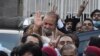 Pakistan's former Prime Minister Nawaz Sharif, center in brown coat, waves to his supporters as he leaves after a court hearing in Islamabad, Pakistan, Dec. 12, 2023. 