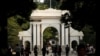 FILE = People walk near the gate of Tsinghua University in Beijing, July 27, 2016. 