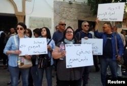 Relatives of Mourad Zghidi, IFM radio journalist who was arrested with Borhan Bsaiss over radio comments and social media posts, carry banners as they call for his release outside the building of the Deanship of Lawyers in Tunis, Tunisia, May 13, 2024.