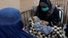 FILE - An Afghan woman with her child is seen in a hospital following an increase in the number of pneumonia cases in Kabul, Afghanistan, Dec. 17, 2022.