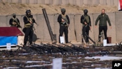 شماری از جنگجویان حشد الشعبی در شمال بغداد، سلاح‌های داعش را ضبط کرده‌اند (تصویر از آرشیف صدای امریکا)‌