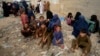 Afghan families wait to board into a bus to depart for their homeland, in Karachi, Pakistan, Oct. 6, 2023.