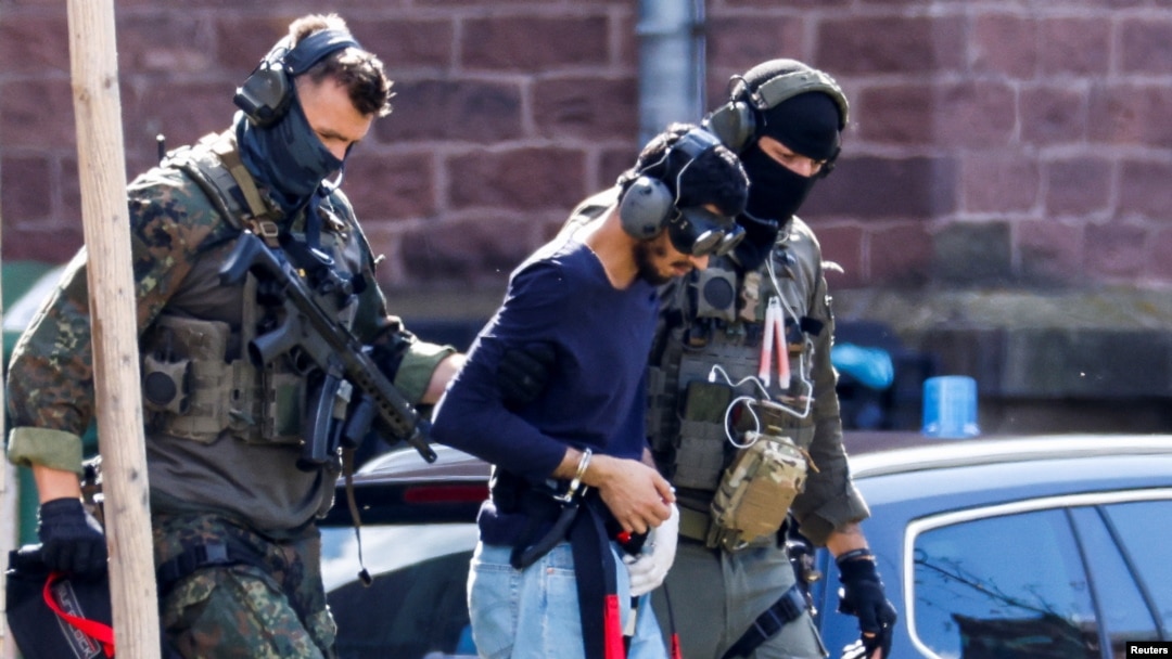 A 26-year-old Syrian man, who is the suspect in custody for a stabbing rampage in the western German city of Solingen, is escorted by police as he leaves the Federal Public Prosecutor's Office in Karlsruhe, Germany, Aug. 25, 2024.