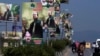 Motorcyclists and cars drive past welcoming banners for Pakistan's self-exiled former prime minister Nawaz Sharif, installed along a highway in Rawalpindi, Pakistan, Oct. 19, 2023. 