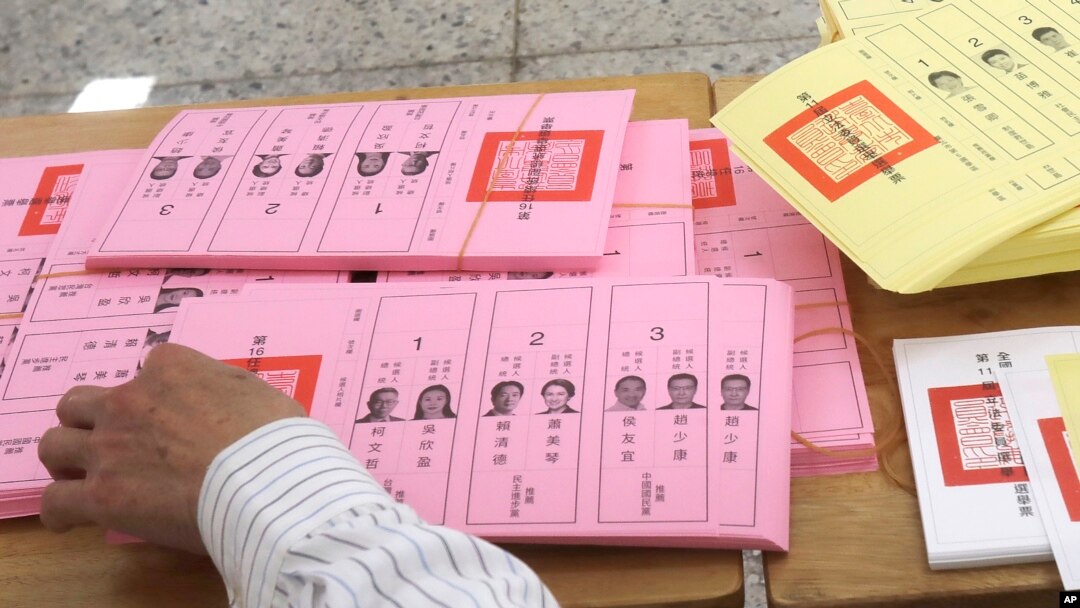 FILE - A staff sorts ballot papers at a polling station in Taipei, Taiwan, Jan. 13, 2024.