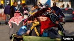 Një vajzë qëndron mbi një karrocë pas largimit nga pjesa lindore e Khan Younis, Gazë (1 dhjetor 2023)