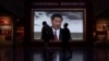Visitors pass a video screen showing Chinese President Xi Jinping at the museum of the Communist Party of China in Beijing, Oct. 19, 2023.