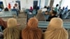 FILE - Afghan women refugees living in Pakistan wait to get registered at an office in Peshawar, Pakistan, Sept. 30, 2021.
