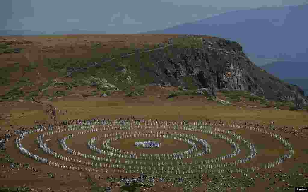 Followers of the Universal White Brotherhood, an esoteric society that combines Christianity and Indian mysticism set up by Bulgarian Peter Deunov in the 1920s, perform a dance-like ritual called "paneurhythmy" in Rila Mountain, Bulgaria, Aug. 19, 2017.
