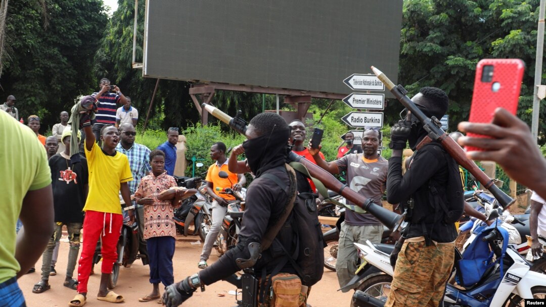 Soldiers carrying heavy weapons escort the convoy of Burkina Faso's self-declared new leader Ibrahim Traore as he arrives at the national television standing in an armoured vehicle in Ouagadougou, Burkina Faso, Oct. 2, 2022.