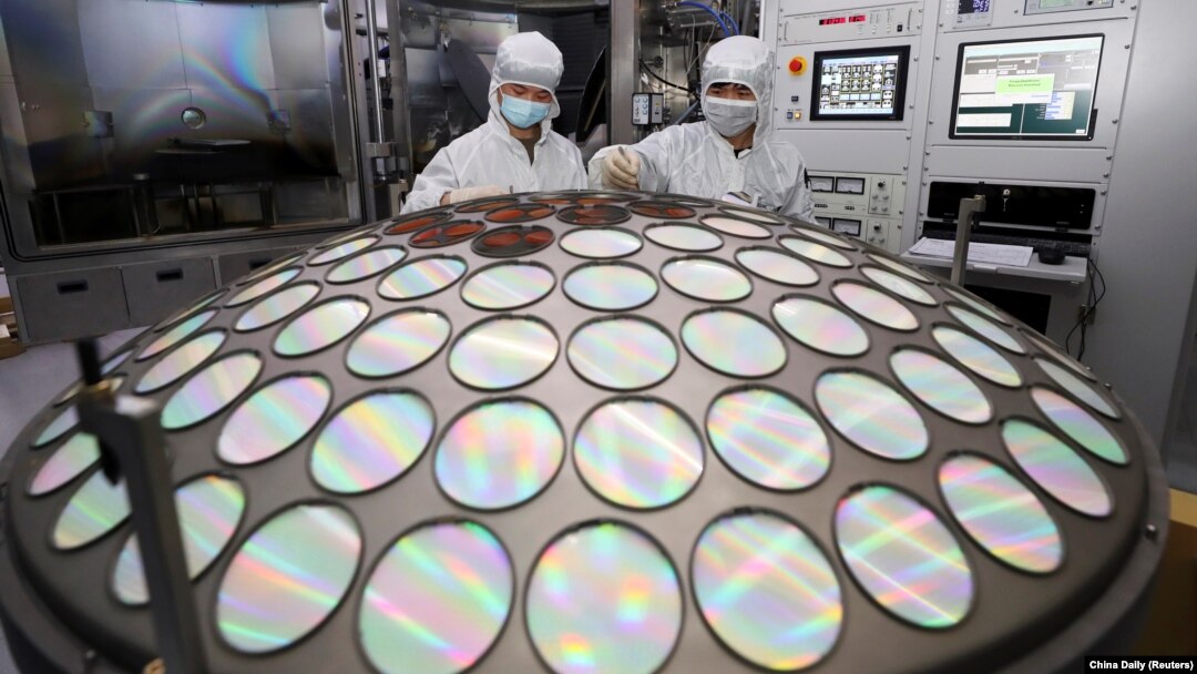 FILE - Employees work on the semiconductor chip production line of Jiangsu Azure Corp in Huaian, Jiangsu province, China, March 25, 2022.