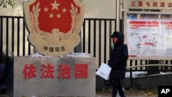 一名北京居民走过三里河街道普法宣传栏。（2021年11月8日）
