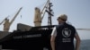 A World Food Program staff member looks on as the MV Brave Commander carrying wheat grain from Yuzhny Port in Ukraine to the drought-stricken Horn of Africa docks in Djibouti, Aug. 30, 2022. (Hugh Rutherford/World Food Program/Handout via Reuters) 