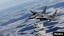 На фото: Винищувач МІГ-29 ВПС Польщі (зверху) та винищувачі Eurofighter Typhoon ВПС Італії беруть участь у патрулі НАТО над Балтією. 10 лютого 2015 р.
