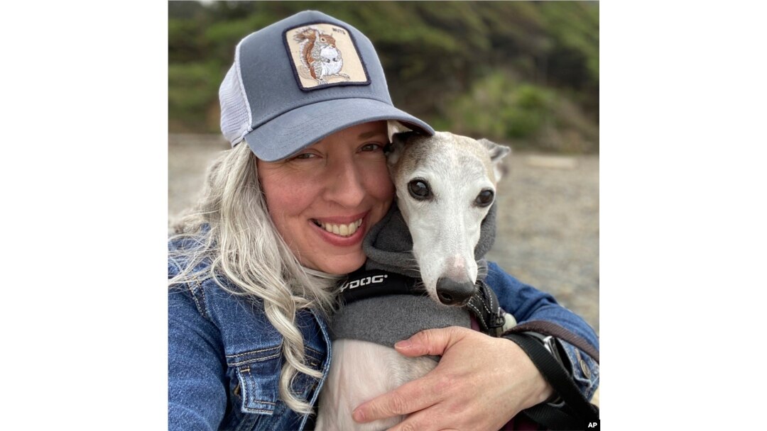 FILE - This photo provided by Amy Watson of Portland, Ore., shows her with her dog during a trip to the Oregon Coast in June 2022.