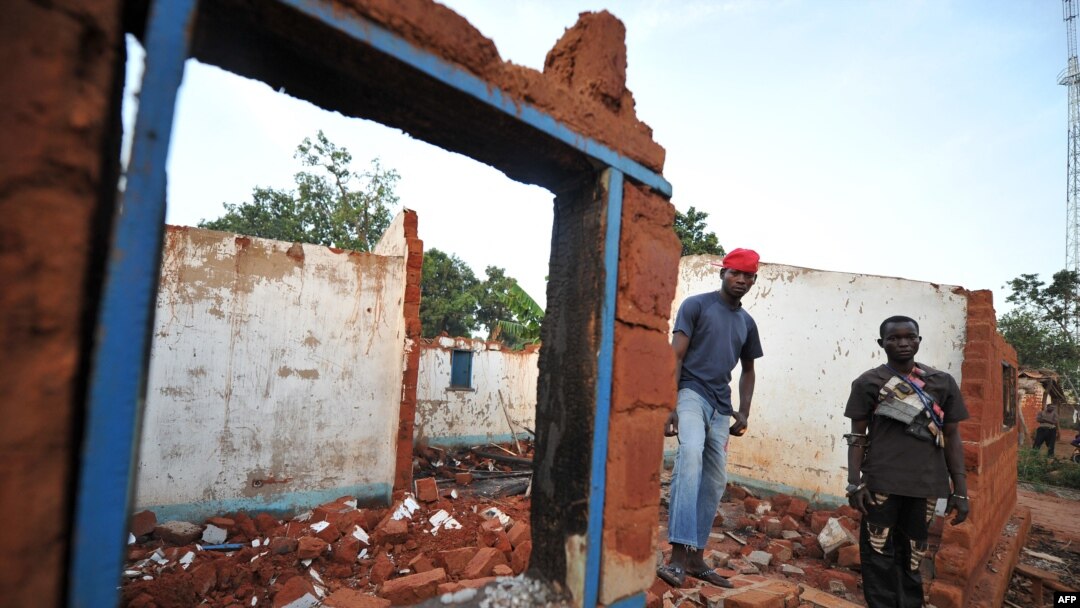 FILE - Members of the anti-Balaka Christian militia stand on March 4, 2014, in the rubbles of the house of one of their leaders destroyed by ex-Seleka rebels in Boali, near Bangui. 