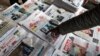 FILE - A man points to a newspaper among the stacks of offerings, in Addis Ababa, Ethiopia, June 24, 2019. 