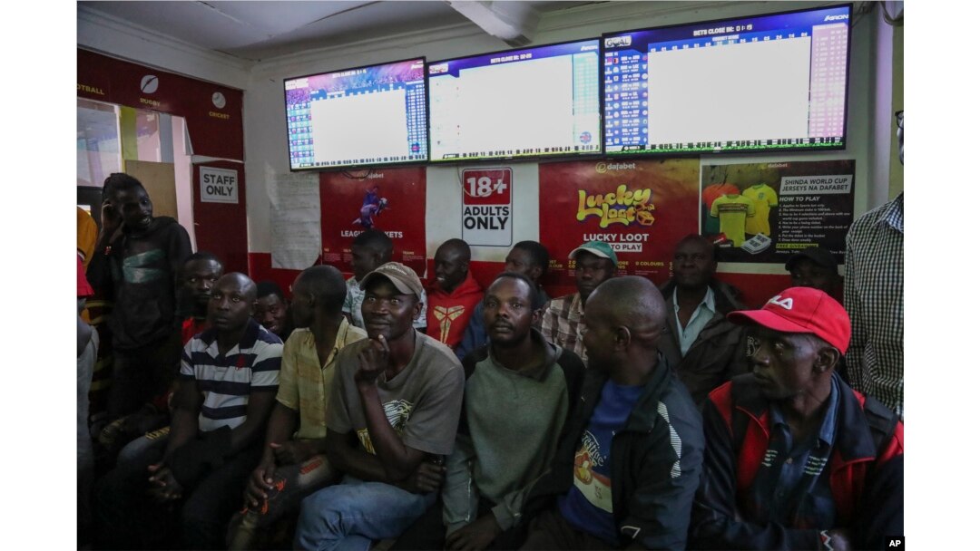 Customers watch screens in a sports betting shop in the low-income Kibera neighborhood of the capital Nairobi, Kenya, Monday, Dec. 5, 2022. (AP Photo/Brian Inganga)