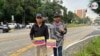 Los migrantes venezolanos Carlos Alexander Briseiro (a la izquierda) y Carlos Millán, sobreviven de la caridad pública en las calles de Ciudad Guatemala, en donde han quedado varados en su ruta hacia EEUU. [Foto: Eugenia Sagastume, VOA]