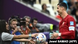 Cristiano Ronaldo recebe a bola de uma jovem apanha-bolas durante o jogo Portugal vs Suíça