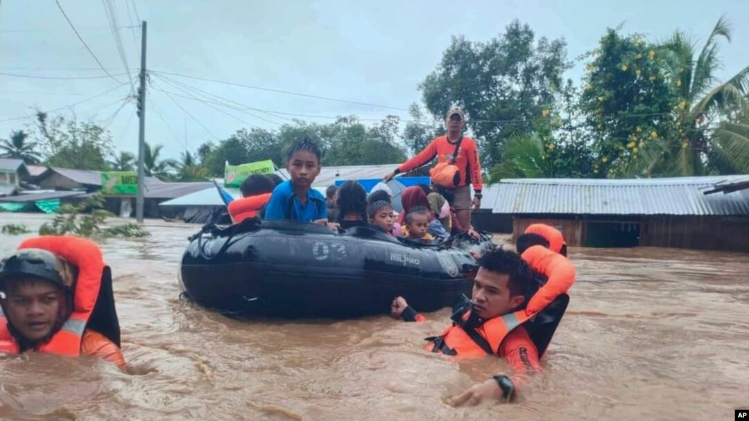 In this photo provided by the Philippine Coast Guard, rescuers use boats to evacuate residents from flooded areas due to Tropical Storm Nalgae at Parang, Maguindanao province, southern Philippines, Oct. 28, 2022. 