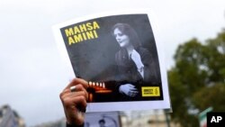 Protestuesit duke mbajtur foton e të ndjerës Mahsa Amini