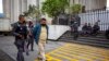 Un sospechoso de pertenecer a una red de trata de personas es escoltado por un oficial al final de su audiencia en la corte, en Ciudad de Guatemala, el 4 de febrero de 2022.