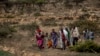 FILE - People walk from a rural area towards a nearby town where a food distribution operated by the Relief Society of Tigray was taking place, near the town of Agula, in the Tigray region of northern Ethiopia, May 8, 2021