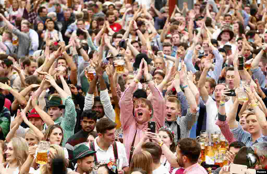 Visitors cheer during the opening day of the 184th Oktoberfest in Munich, Germany, Sept. 16, 2017.