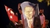 Men, holding a banner with a picture of Turkey's President Recep Tayyip Erdogan, celebrate outside his Justice and Development Party, or AKP, headquarters in Istanbul, June 24, 2018.