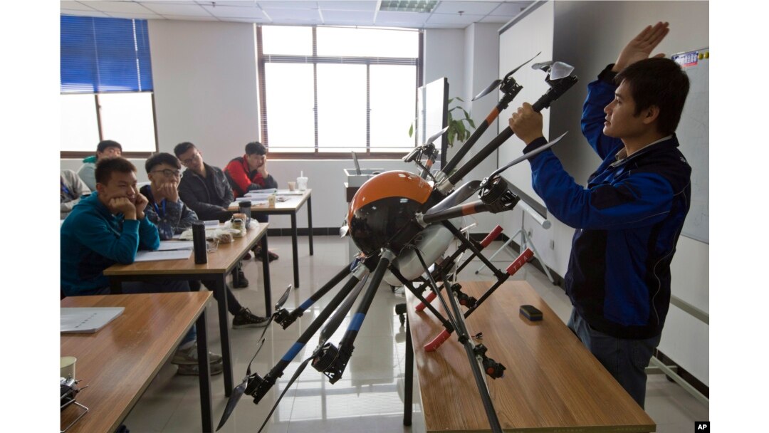 FILE - An instructor explains the operation of a drone to students at a school run by TT Aviation Technology in Beijing, Oct. 17, 2015. China has quickly emerged as a leading player in the international race for drone manufacturing.