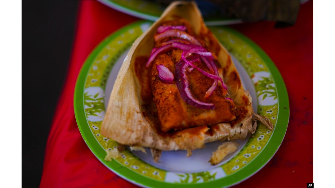 A Cochinita Pibil style tamal is displayed during theTamales fair at the Ixtapalapa neighborhood of Mexico City, Friday, Jan. 27, 2023. Cochinita pibil is a traditional Yucatec Mayan slow-roasted pork dish from the Yucatán Peninsula. (AP Photo/Fernando Llano)