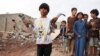 A boy holds shrapnel from a missile at the site of Houthi missile attack, in Marib, Yemen, Oct. 3, 2021.