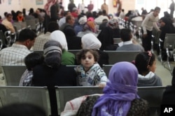 FILE - Australian Foreign Minister Julie Bishop visits a Syrian refugee compound in Amman, Jordan, to meet with UNHCR representative to Jordan Andrew Harper, regarding the Syrian refugee situation, April 21, 2014.