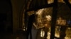 Faithful stand outside a closed for the public Greek Orthodox church as a priest takes part in the Good Saturday ceremony, in the northern city of Thessaloniki, Greece, during a lockdown order, April 19, 2020.