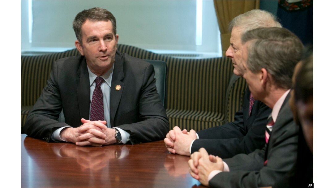 FILE - Virginia Gov. Ralph Northam, left, address State Senators and Delegates as they gather to inform him that they are ready to adjourn the 2018 session of the Virginia General Assembly at the Capitol in Richmond, Va., March 10, 2018.