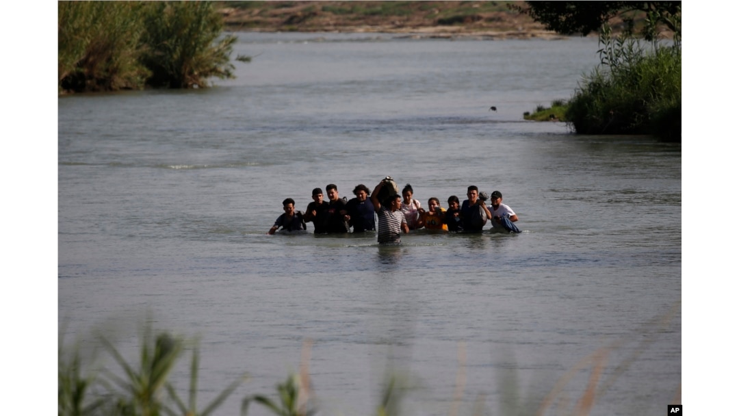 FILE - Migrants, mostly from Nicaragua, cross the Rio Grande River into the U.S., at Eagle Pass, Texas, May 20, 2022.