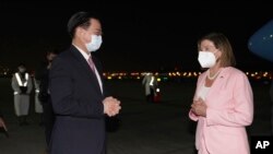美国国会众议院议长佩洛西2022年8月2日晚抵达台北松山机场后与迎接她的台湾外长吴钊燮交谈。