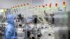 FILE - Employees wearing protective equipment work at a semiconductor production facility for Renesas Electronics during a government organized tour for journalists in Beijing, on May 14, 2020. 