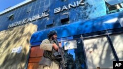Tolibon askari bankni qo'riqlamoqda, Kobul, Afg'oniston, 2022-yil, 13-fevral.