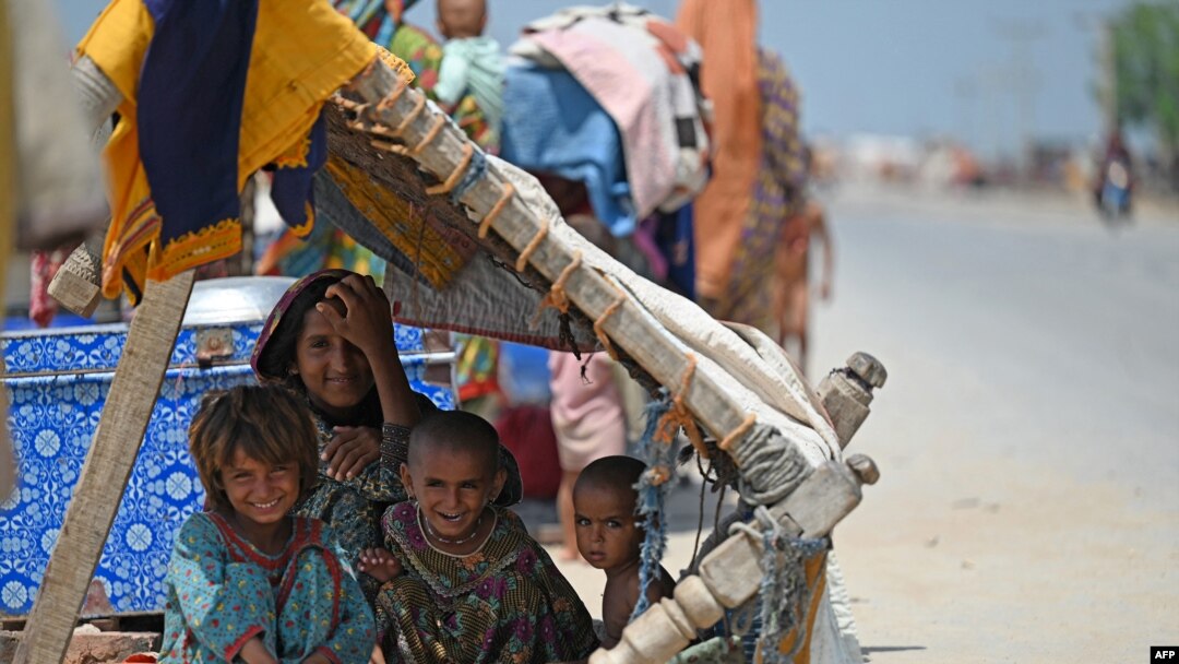 Internally displaced flood-affected children rest under makeshift shelter along a road in higher ground in flooded area after heavy monsoon rains on the outskirts of Jacobabad, Sindh province, Sept. 6, 2022.