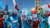 Women carry posters of newly-elected Somalian President Mohamed Abdullahi Farmajo as they celebrate his victory, near the Daljirka Dahson monument in Mogadishu, Somalia, Feb. 11, 2017. Other city residents rallied, pressing for greater political representation.